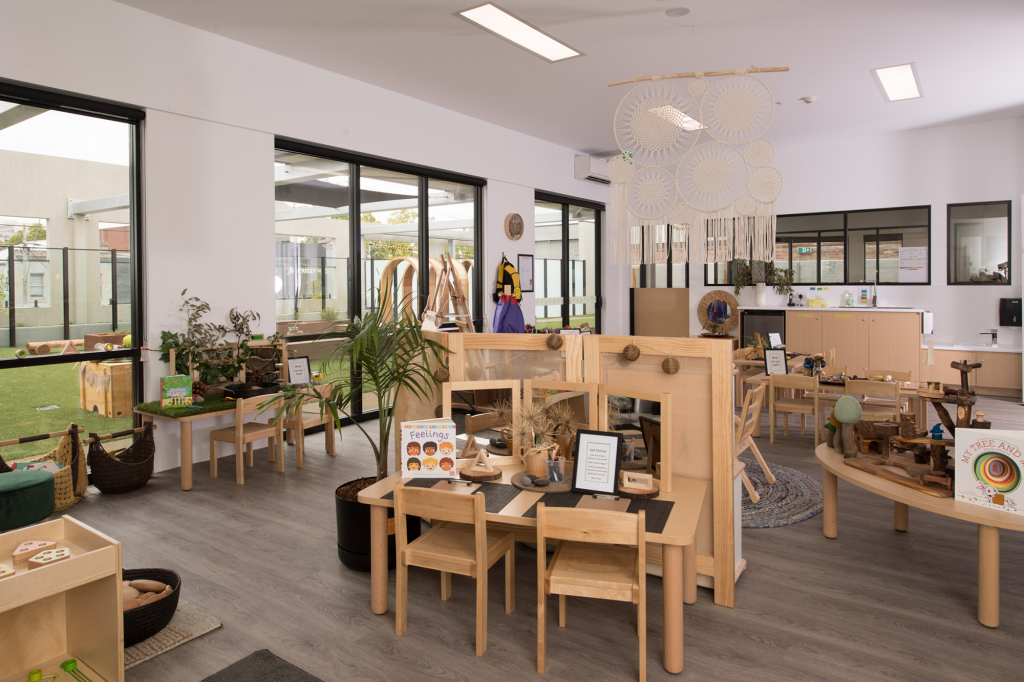 Childcare centre toddlers room complete with play equipment and experiences for children with view out to outdoor playspace