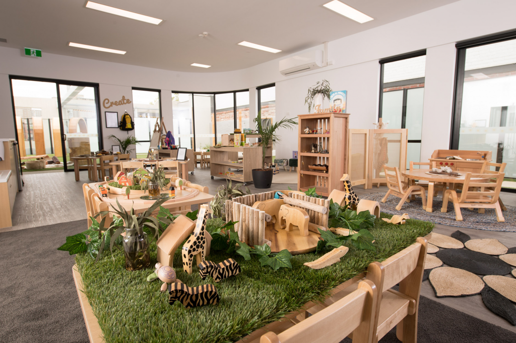 Childcare centre toddlers room complete with play equipment and activities for children, with view out to outdoor playspace at Fitzroy ELC